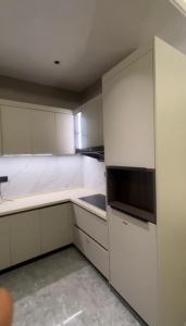 a kitchen with white cabinets and a microwave at Cassava street in Abuja