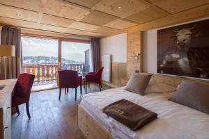 a bedroom with a bed with a picture of a deer on the wall at Hotel Etrier in Crans-Montana +35 photos
