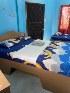 een blauwe slaapkamer met een groot bed en een dekbed bij John Lhea Beach Cottages in Siquijor