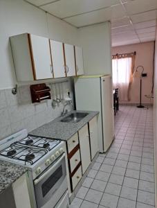 eine Küche mit einem Herd, einer Spüle und einem Kühlschrank in der Unterkunft Casa España in San Antonio Oeste