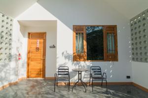 a room with chairs and a table and a window at Baansiwalin in Phra Nakhon Si Ayutthaya