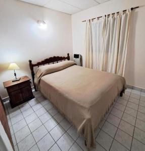 ein Schlafzimmer mit einem großen Bett und einem Nachttisch in der Unterkunft Casa España in San Antonio Oeste