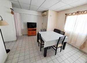 ein Esszimmer mit Tisch und Stühlen und einem Fernseher in der Unterkunft Casa España in San Antonio Oeste