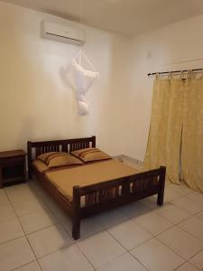 une chambre avec un lit et une lumière sur le mur dans l'établissement Les jardins d'Ambondrona, à Mahajanga