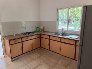 une cuisine vide avec un évier et une fenêtre dans l'établissement Les jardins d'Ambondrona, à Mahajanga