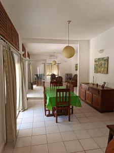 une cuisine et un salon avec une table et des chaises vertes dans l'établissement Les jardins d'Ambondrona, à Mahajanga