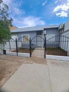 ein Haus mit einem Tor davor in der Unterkunft Casa España in San Antonio Oeste