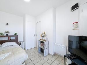 a bedroom with a bed and a flat screen tv at Unique Chambre 1 Centre Équestre Snack in Vic-le-Comte
