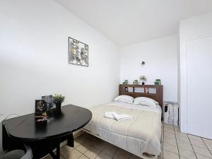 a bedroom with a bed and a table in it at Unique Chambre 1 Centre Équestre Snack in Vic-le-Comte