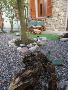 a garden with a tree and a bench in front of a house at Appartamento La Ciliegia in Sovere