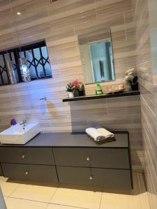 a bathroom with a sink and a mirror at Knovi Guesthouse in Bulawayo +14 photos