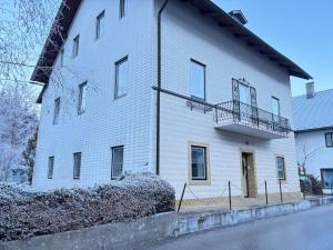 a white building with a balcony on the side of it at Ferienwohnung Hakuna Matata in Bad Aussee