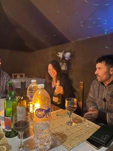 a group of people sitting at a table with wine glasses at Luxury camp in Hassilabied +38 photos