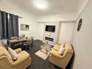 a living room with two couches and a table at Cosy Bungalow house in the centre of Sunderland in Sunderland