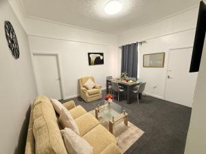 a living room with a couch and a table at Cosy Bungalow house in the centre of Sunderland in Sunderland +2 photos