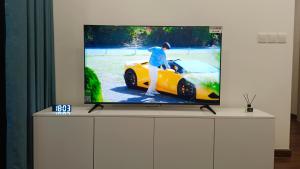 a tv on a stand with a race car on it at Masteri West Heights 3Br near Korean Town in Phú Thú