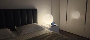 a bedroom with a bed with a lamp on a night stand at Masteri West Heights 3Br near Korean Town in Phú Thú