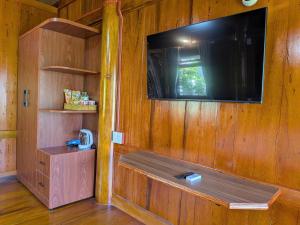 a room with a wooden wall with a flat screen tv at Homely House Bảo Lộc in Ấp Tân Hà