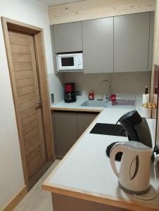 a kitchen with white cabinets and a white counter top at Studio Mont d'Arbois in Megève +16 photos