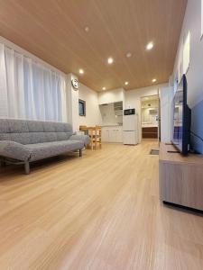 a living room with a couch and a flat screen tv at Private Room near Iriya in Tokyo
