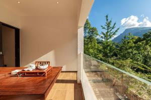a balcony with a table and a large window at Jade Peak Hot Spring Villa in Dujiangyan +103 photos