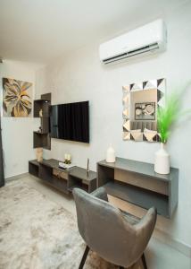 a living room with a chair and a television at Accra Luxury Apartments at The Bantree in Accra