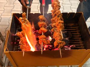 Un montón de comida en brochetas en una parrilla en Yelagiris Honey Stay, en Yelagiri