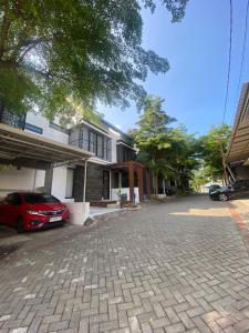 een rode auto geparkeerd voor een huis bij Omah Sulaem Homestay in Blimbing +28 foto's