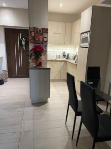 a kitchen with a table with a vase of flowers on it at Nice Wellness Apartman in Siófok