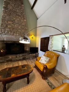 Una sala de estar con un sofá y una chimenea. en Gîtes du Gohic - L'Ecurie, en Quistinic