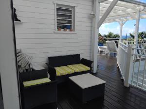 a porch with a bench and a table and a window at Kote mer Villa Bayside in Sainte-Anne +6 photos