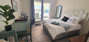 Un dormitorio con una cama y una ventana grande. en Sufi'Sawd Guest Rooms Muizenberg, en Muizenberg