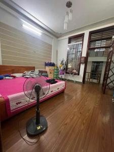 ein Schlafzimmer mit einem Bett und einem Ventilator auf dem Boden in der Unterkunft Tan Home Deluxe in Kon Rung (1)