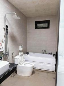 ein Badezimmer mit Badewanne, Toilette und Waschbecken in der Unterkunft Tan Home Deluxe in Kon Rung (1)