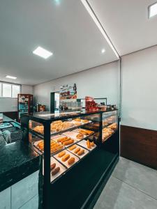 a bakery with a display case filled with donuts at Parada Guanabara in Belo Oriente