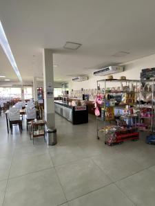 a grocery store with a table and chairs in a room at Parada Guanabara in Belo Oriente
