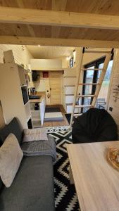 ein kleines Wohnzimmer mit einer Couch und einem Tisch in der Unterkunft Fichtel-Tiny - Mit Hot Tub oder Sauna gegen Aufpreis in Hohenberg an der Eger