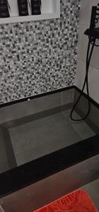 a bathroom with a black and white tiled wall at Pousada Paraíso Guapi in Guapimirim