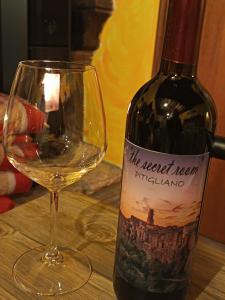 een fles witte wijn naast een wijnglas bij The secret room in Pitigliano +33 foto's