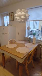 a dining room table with chairs and a refrigerator at Lejlighed ved havet in Lønstrup