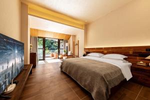 a bedroom with a large bed and a large window at Jade Peak Hot Spring Villa in Dujiangyan