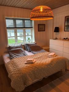 ロンストラップにあるLejlighed ved havetの大きなベッドとシャンデリアのある寝室