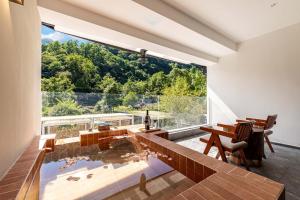 a large window in a room with a table and chairs at Jade Peak Hot Spring Villa in Dujiangyan