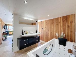 a bathroom with a white tub and a sink at Unique Cabane 4 spa Centre Équestre & Snack in Vic-le-Comte