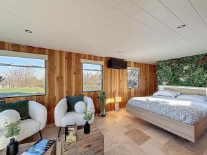 a bedroom with a bed and a couch and a tv at Unique Cabane 4 spa Centre Équestre & Snack in Vic-le-Comte