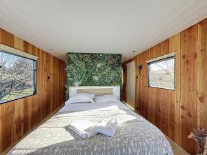 a large bed in a room with wooden walls at Unique Cabane 4 spa Centre Équestre & Snack in Vic-le-Comte