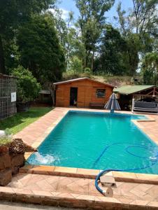 Una piscina en un patio con un edificio. en Hospedaje Cabaña completa, en Rivera