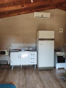Una cocina con un refrigerador blanco y un fregadero. en Hospedaje Cabaña completa, en Rivera