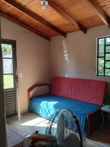 1 dormitorio con 1 cama con colcha roja y azul en Hospedaje Cabaña completa, en Rivera