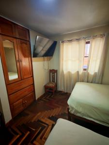 um quarto com 2 camas, um armário e uma janela em hawka pacha cusqueña em Cusco